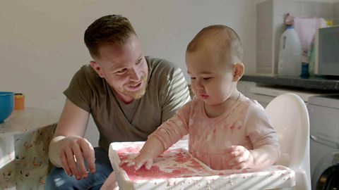 A dad and his daughter playing with jelly.