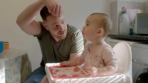 A dad lifting some jelly as his young daughter looks on.