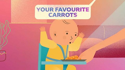 A baby being handed a plate of food as their parent says 'your favourite, carrots'.