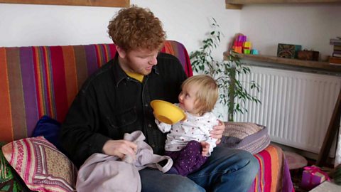 A little girl showing her big brother the bowl she has pulled out of the pillowcase.