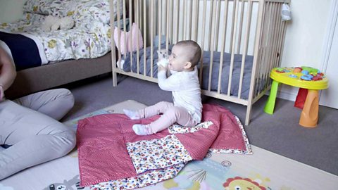 A baby girl excited as she holds her teddy.