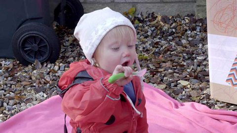 A little girl with a spoon.