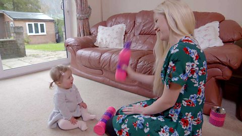 A mum shaking a homemade shaker for her young daughter.