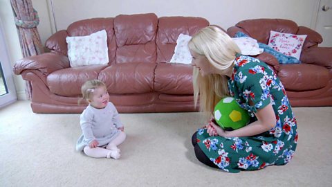 A mum playing on the floor with her little girl.