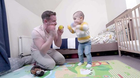 A dad and his daughter clapping cups together.