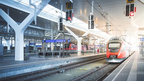 A photo of a train station. There is a train pulled in at the platform.