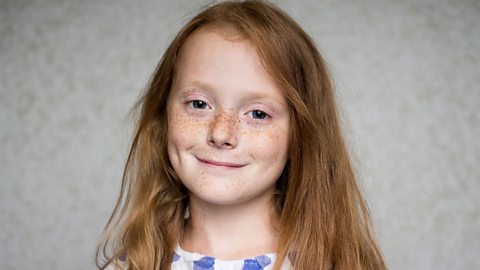 A photo of a young girl with freckles