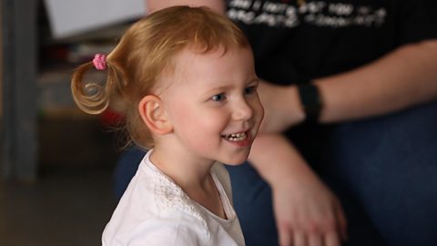 Little girl smiling to the right.