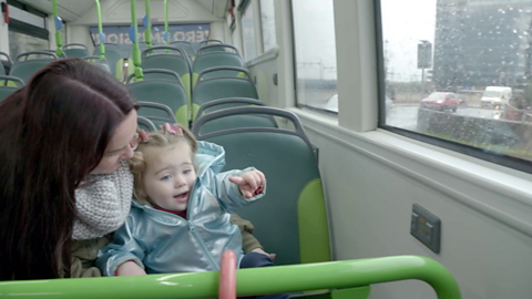 Woman on bus with her toddler who is pointing