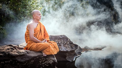 Buddhism – A Buddhist monk meditating outdoors