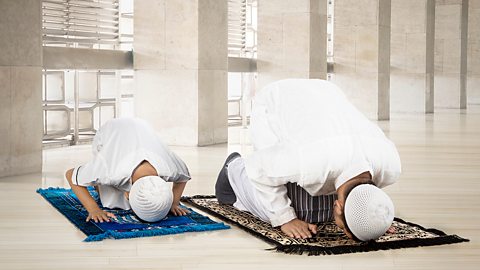 Islam – A father and son pray together at the mosque
