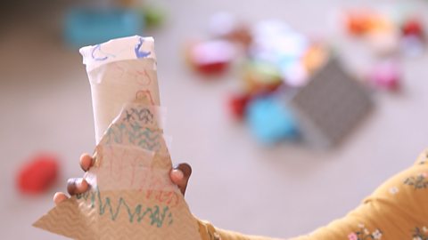 Cardboard tube decorated with coloured pens.