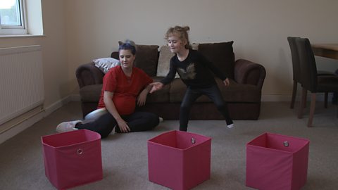 Little girl with 3 pink boxes in front of her.