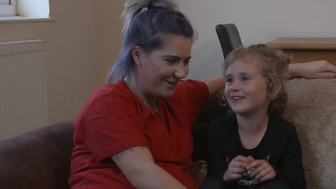 Mum and daughter on the sofa laughing.