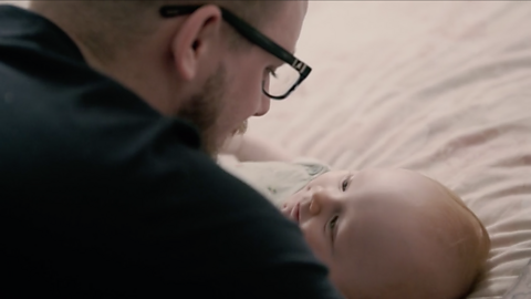 Baby and dad looking at each other.