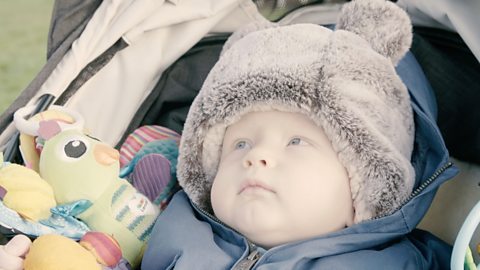 Baby in pram looking upwards.