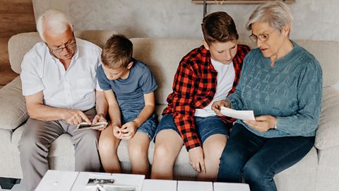 Two boys with their grandparents looking at photographs