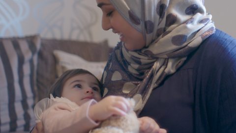 Mum cradling her baby and looking into their eyes.