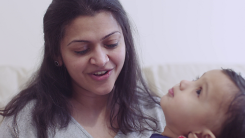 Mum singing while her toddler looks upwards.