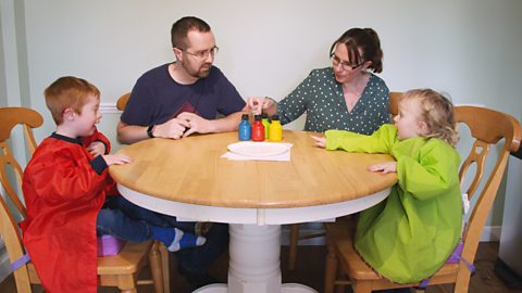 A family sat around the table, ready to do finger painting.