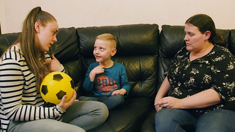 A little boy talking to his big sister about a ball.