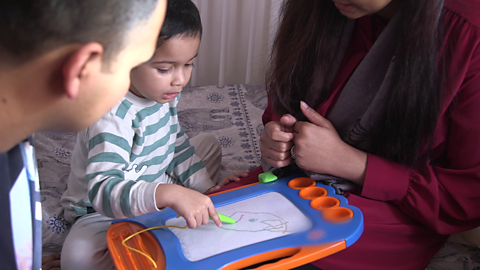 Close up of boy using drawing toy