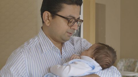 Dad sings to baby he is holding