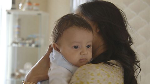 Close up of baby being held by mum