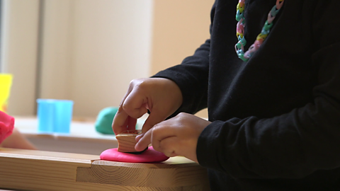 Close up of young girl using play dough.