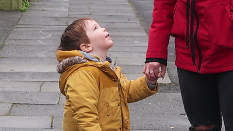 Boy looking up to talk to his mum.