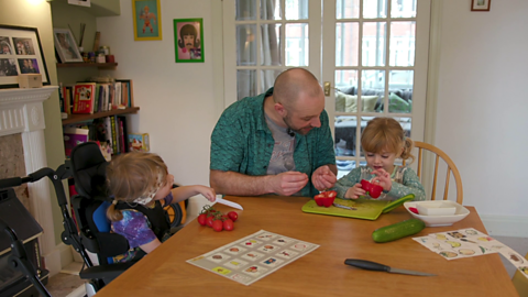 Dad and two children sat at dinner table. 