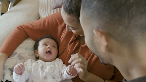 Baby looking up at mum and dad