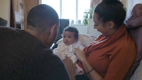 Mum and dad looking at baby