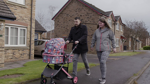 Mum and dad pushing pram outside