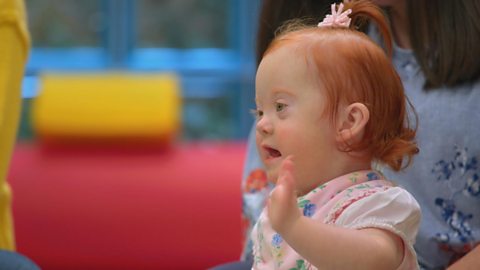 A baby girl waving.