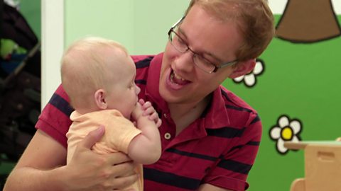 A dad making a noise to his baby.