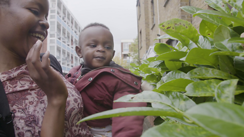 Toddler and mum looking at a hedge 