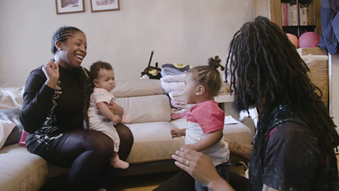 Family sat down and smiling.