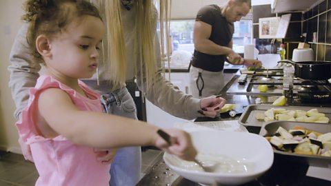 Toddler in kitchen whisking 