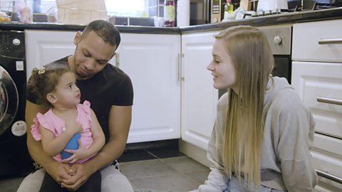 Toddler chatting with parents in kitchen