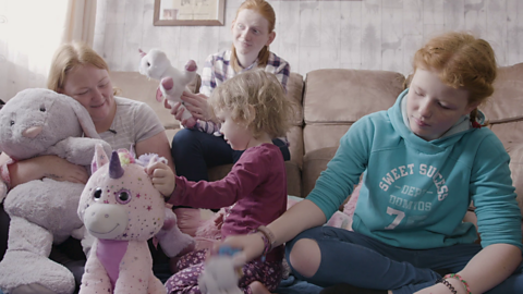 Family playing with cuddly toys.