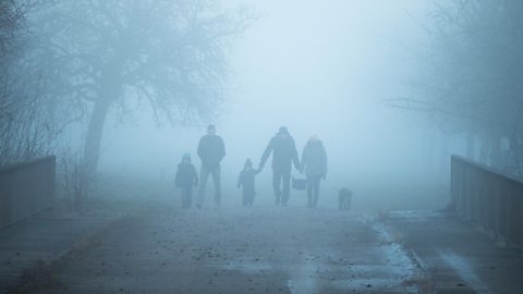 A family walking along a road on a foggy day