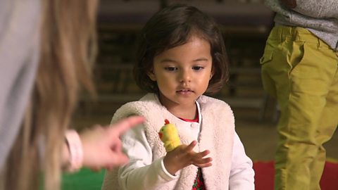 A little girl with a finger puppet.