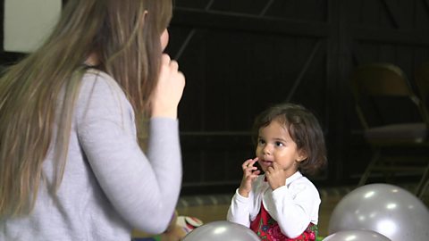 A girl and her mum singing an action rhyme.