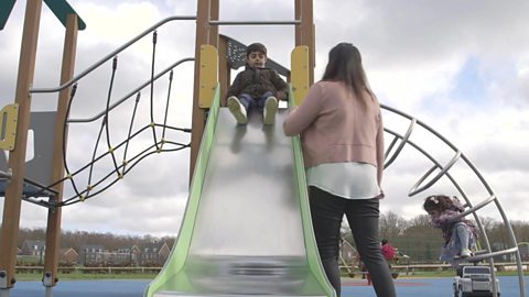 Ashir waits with her son on a slide.