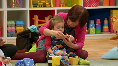 Toddler and grandma play with a hand mirror at The Baby Club