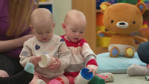 Two babies playing with plastic cups