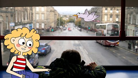 A boy in a bus investigates traffic in a town centre