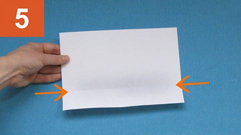 Step 5: Arrows point to a fold line on a piece of paper