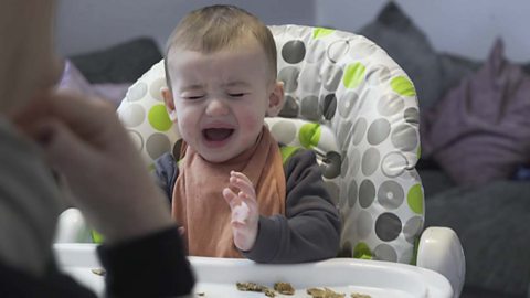 A baby crying about a food he doesn't like.